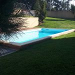 Piscina rodeada por relva e árvores com uma fantástica mistura entre conforto e natureza